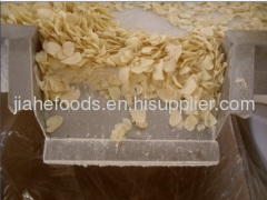 garlic flakes through metal strips