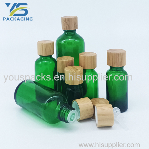 Transparent green empty glass bottle with bamboo screw cap