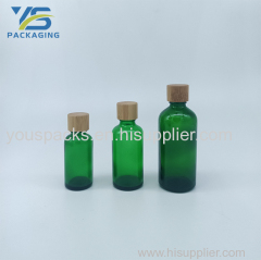 Transparent green empty glass bottle with bamboo screw cap