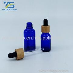 Transparent blue essential oil persone using glass bottle with black dropper