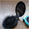 Oval shaped plastic case mirror with comb